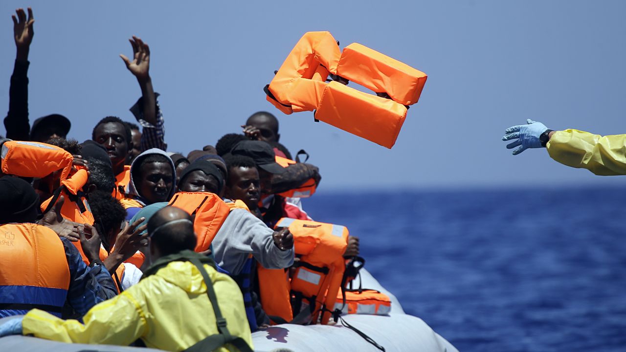 A Belgian Navy sailor passes life jackets to migrants during a search-and-rescue mission Tuesday, June 23, in the Mediterranean Sea. Calm seas and good weather have been prompting <a href="http://www.cnn.com/2015/06/07/europe/mediterranean-migrants-rescue/index.html" target="_blank">a wave of migrant ships</a> to attempt the crossing from Libya to Italy, the International Organization for Migration said earlier this month.