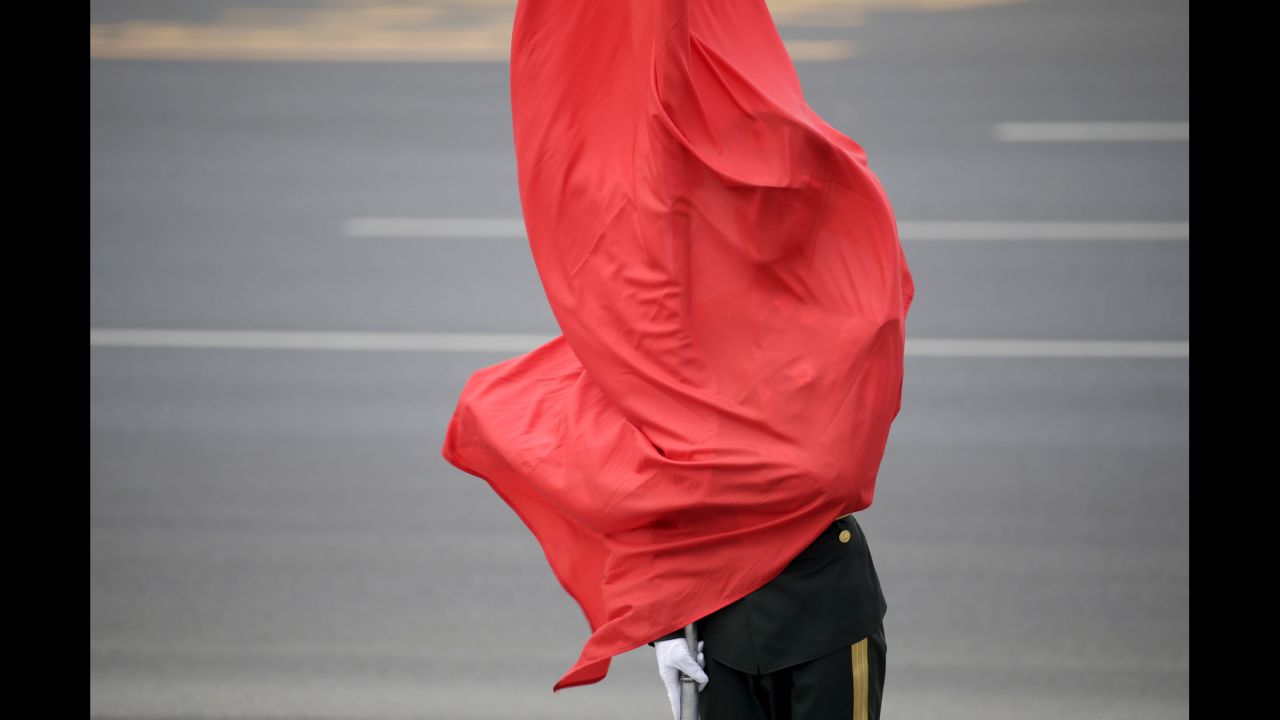 A flag covers an honor guard soldier in Bejiing during a welcoming ceremony for Belgium's King Philippe on Tuesday, June 23.