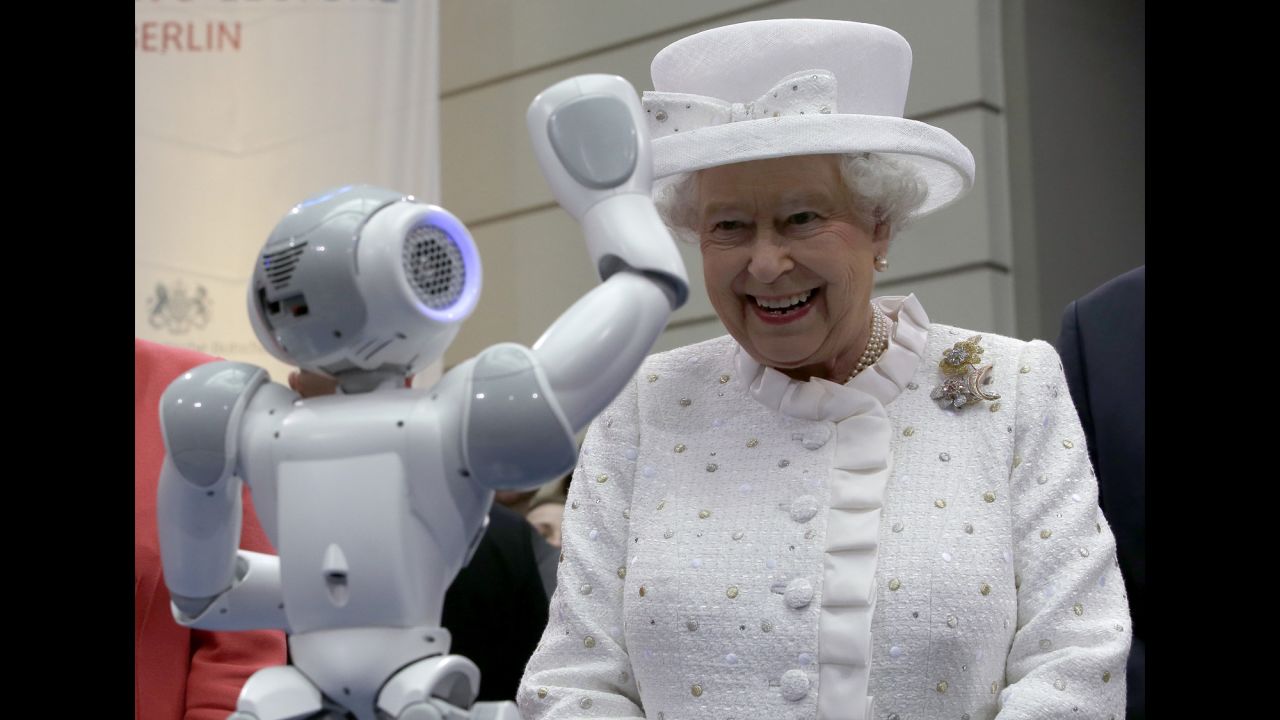 Britain's Queen Elizabeth II smiles as a robot waves to her during a reception at the Technical University in Berlin on Wednesday, June 24.