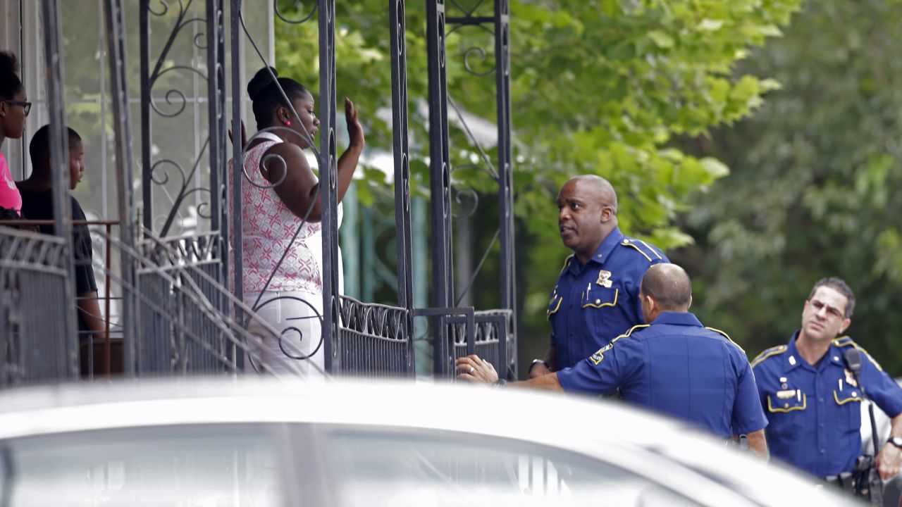 Police talk to people on a porch in New Orleans as they search for the person who fatally shot a New Orleans police officer on Saturday, June 20. A suspect was taken into custody 24 hours after <a href="http://www.cnn.com/2015/06/20/us/new-orleans-police-officer-killed/" target="_blank">the shooting death of Officer Daryle Holloway.</a>