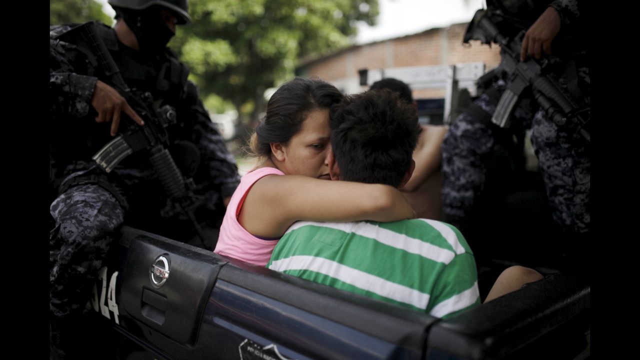 A woman kisses a suspected gang member as he is arrested during a police and army operation in San Salvador, El Salvador, on Sunday, June 21. The operation took place after two soldiers were killed by gang members, local media reported.