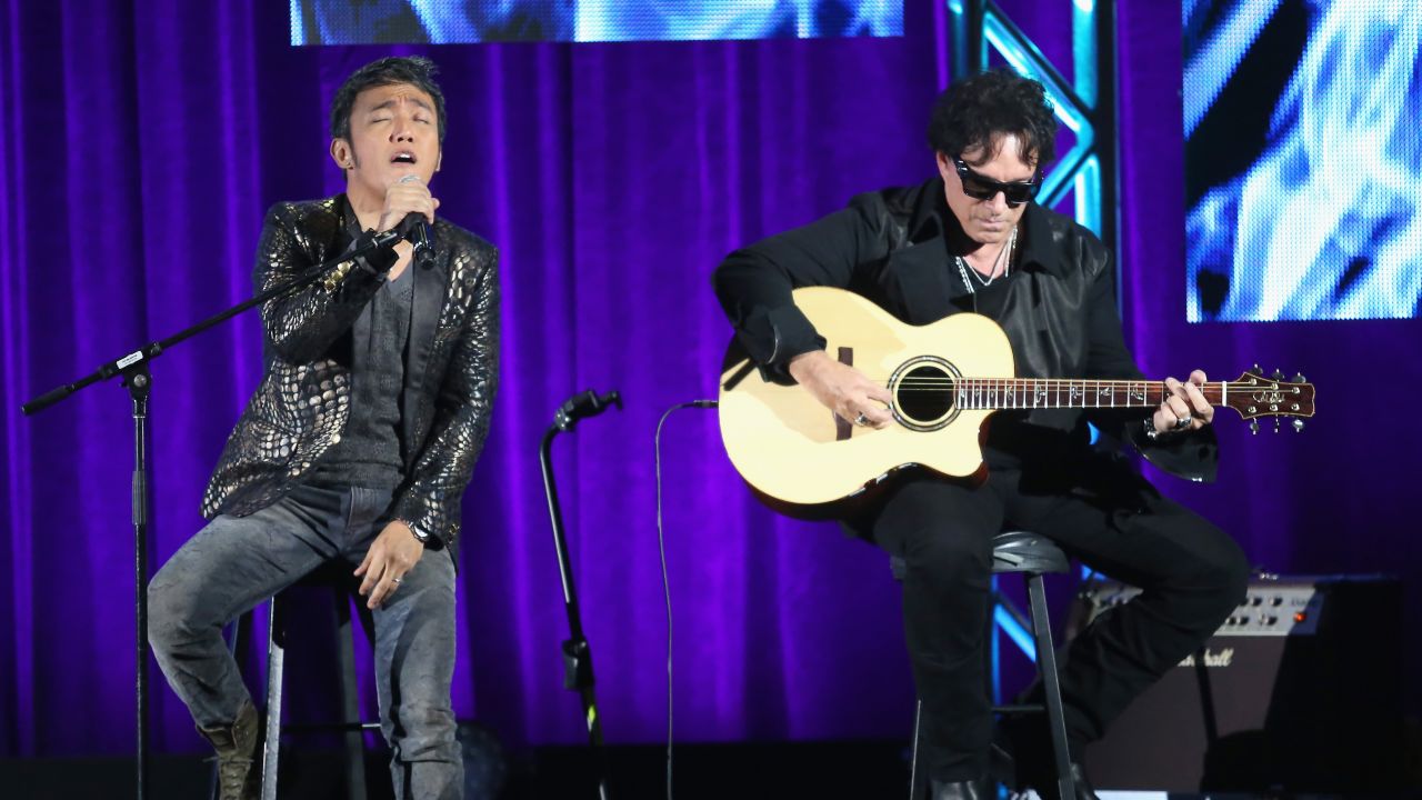 (L-R) Journey band members lead vocalist Arnel Pineda and guitarist Neal Schon perform onstage during the "Don't Stop Believin': Everyman's Journey" panel at the PBS portion of the 2013 Summer Television Critics Association tour at the Beverly Hilton Hotel on August 6, 2013 in Beverly Hills, California. 