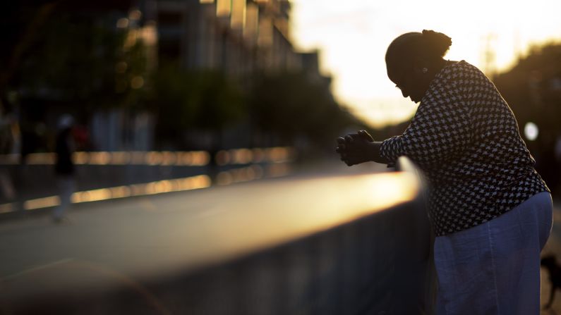As the sun rises on June 26, Doris Simmons stands across the street from the Charleston church where the shooting took place earlier this month.