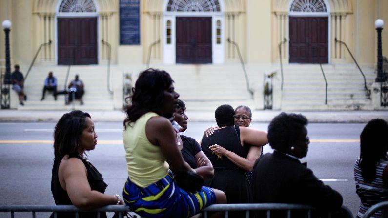 People embrace while waiting to enter Pinckney's funeral service.