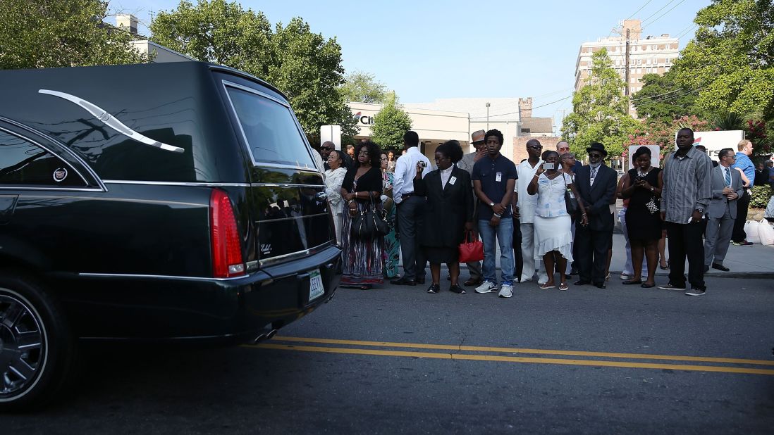People watch as the hearse carrying Pinckney passes by June 26 in Charleston. 