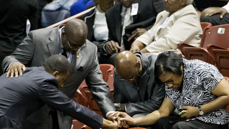 Mourners pray before the service.