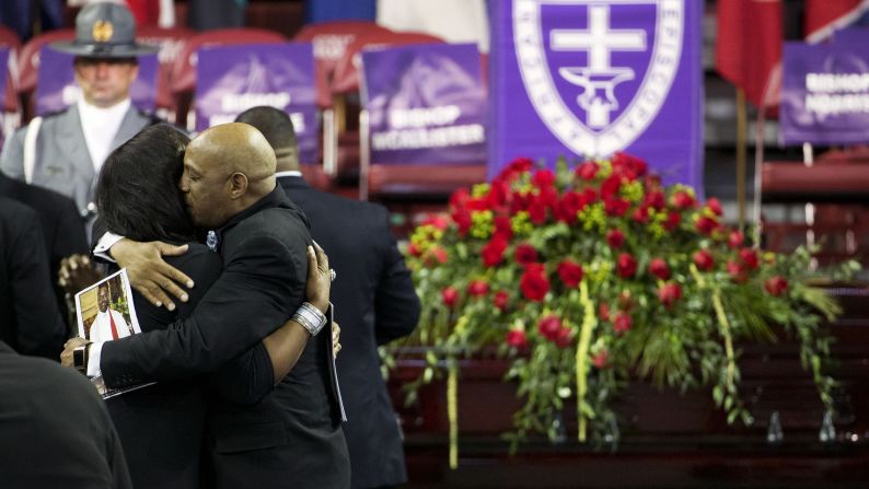 Mourners embrace next to Pinckney's casket.