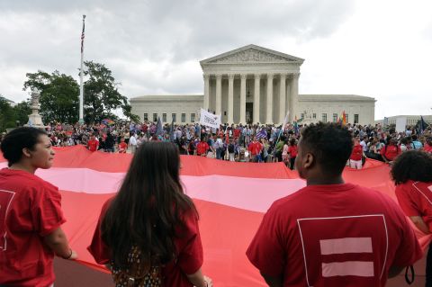 People wave a giant equality flag as they celebrate outside the Supreme Court on June 26.