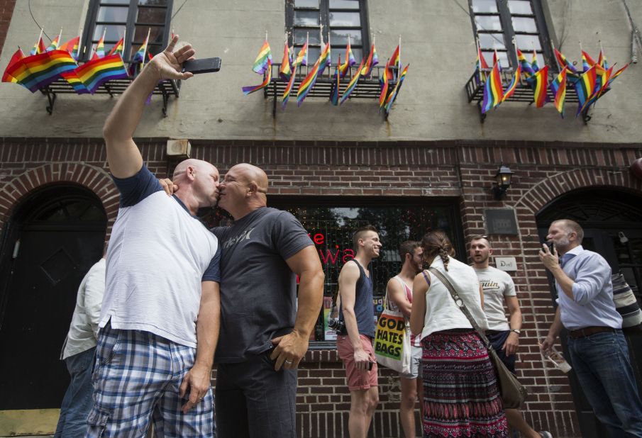 Doug Mest, left, and Mark Pelekakis kiss outside the Stonewall Inn in New York, the site of the 1969 Stonewall riots and an iconic bar in the LGBT community.