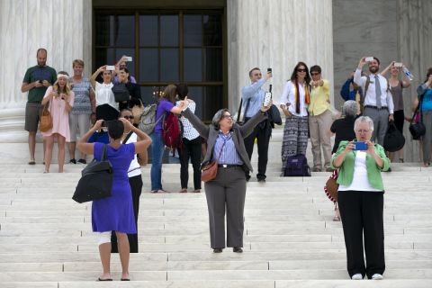 Chris Svoboda, president of the Virginia Equality Bar Association, raises her arms in victory on the steps of the Supreme Court on June 26.