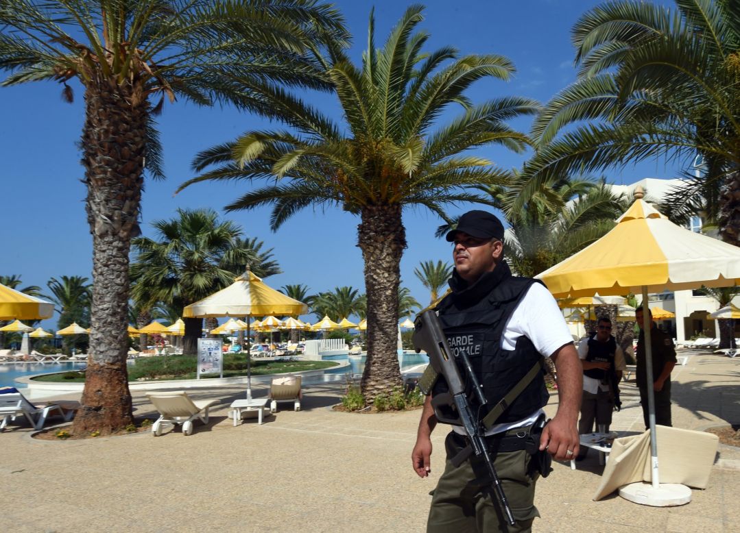 A Tunisian security member stands next to a swimming pool at the hotel.