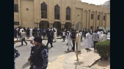 Security forces, officials and civilians gather outside of the Imam Sadiq Mosque after a deadly blast struck after Friday prayers in Kuwait City, Kuwait, Friday, June 26, 2015. There was no immediate claim of responsibility for what appears to be a bombing that targeted the Shiite mosque.