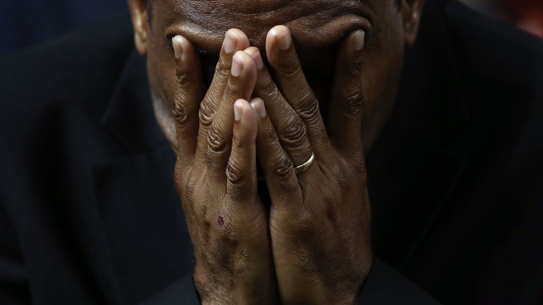 A mourner bows his head in prayer.