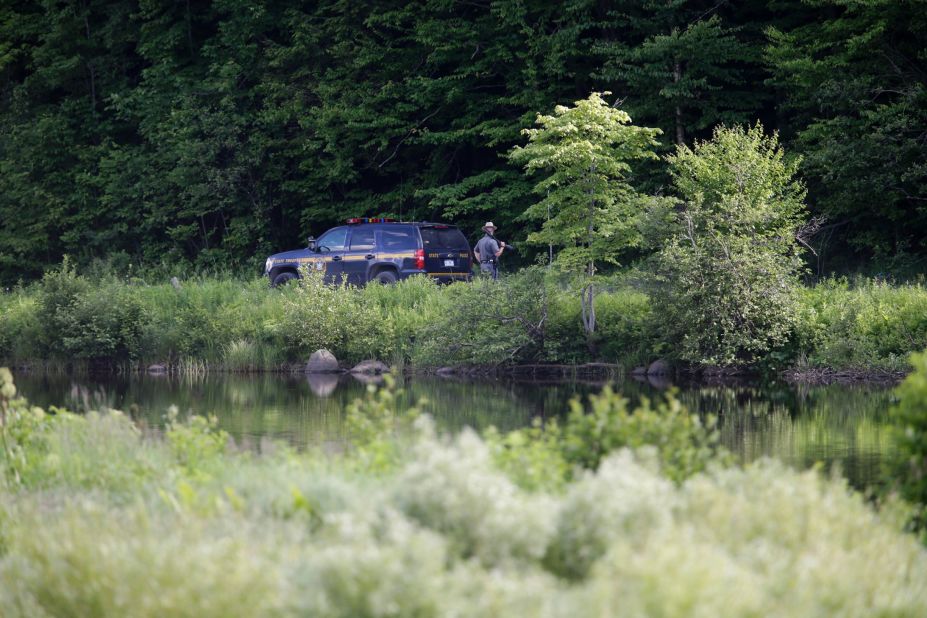 A New York State Police officer stands guard near the shooting scene in Malone on June 26.