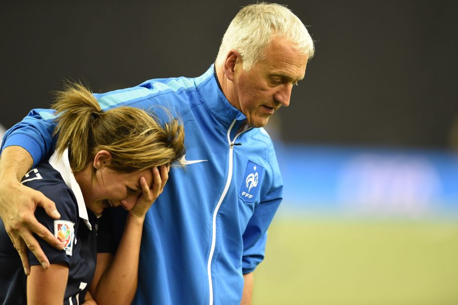 France's Claire Lavogez is consoled by head coach Philippe Bergeroo after she missed her penalty in the shootout. 