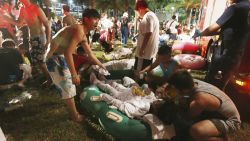 Emergency rescue workers and concert spectators tend to injured victims from an explosion during a music concert at the Formosa Water Park in New Taipei City, Taiwan, Saturday, June 27, 2015. The New Taipei City fire department says 200 people were injured in an accidental explosion of colored theatrical powder Saturday night near a performance stage where about 1,000 people were gathered for party. (AP Photo) TAIWAN OUT