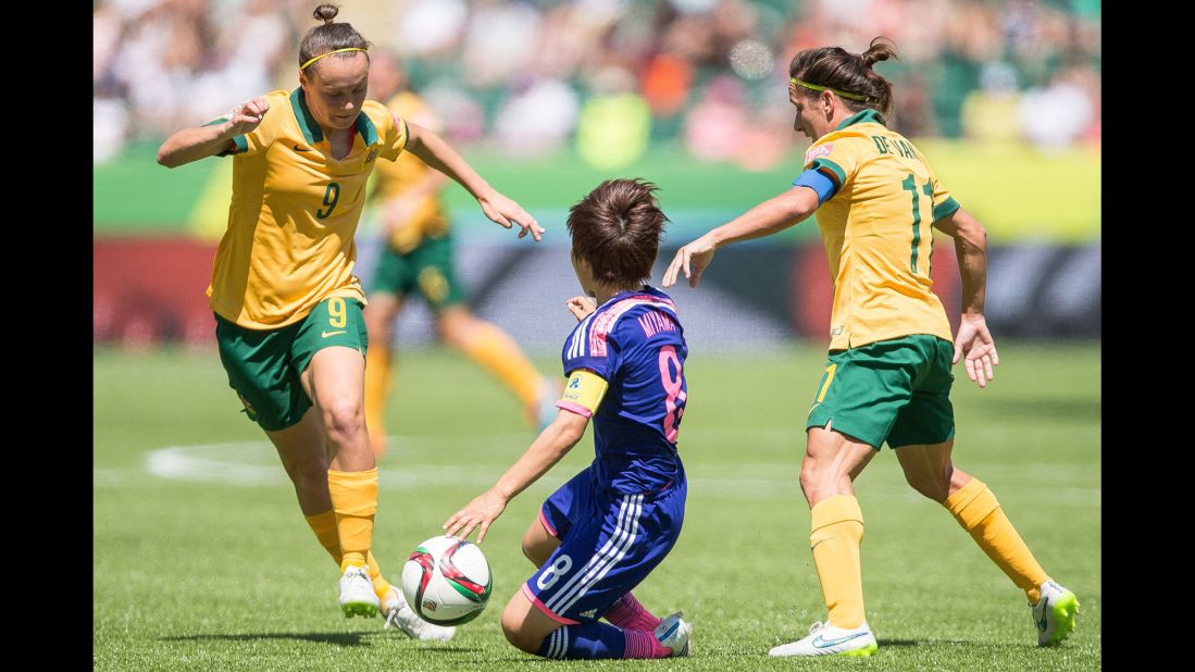 Australia's Caitlin Foord, left, and Lisa De Vanna try to keep the ball from Japan's Aya Miyama.