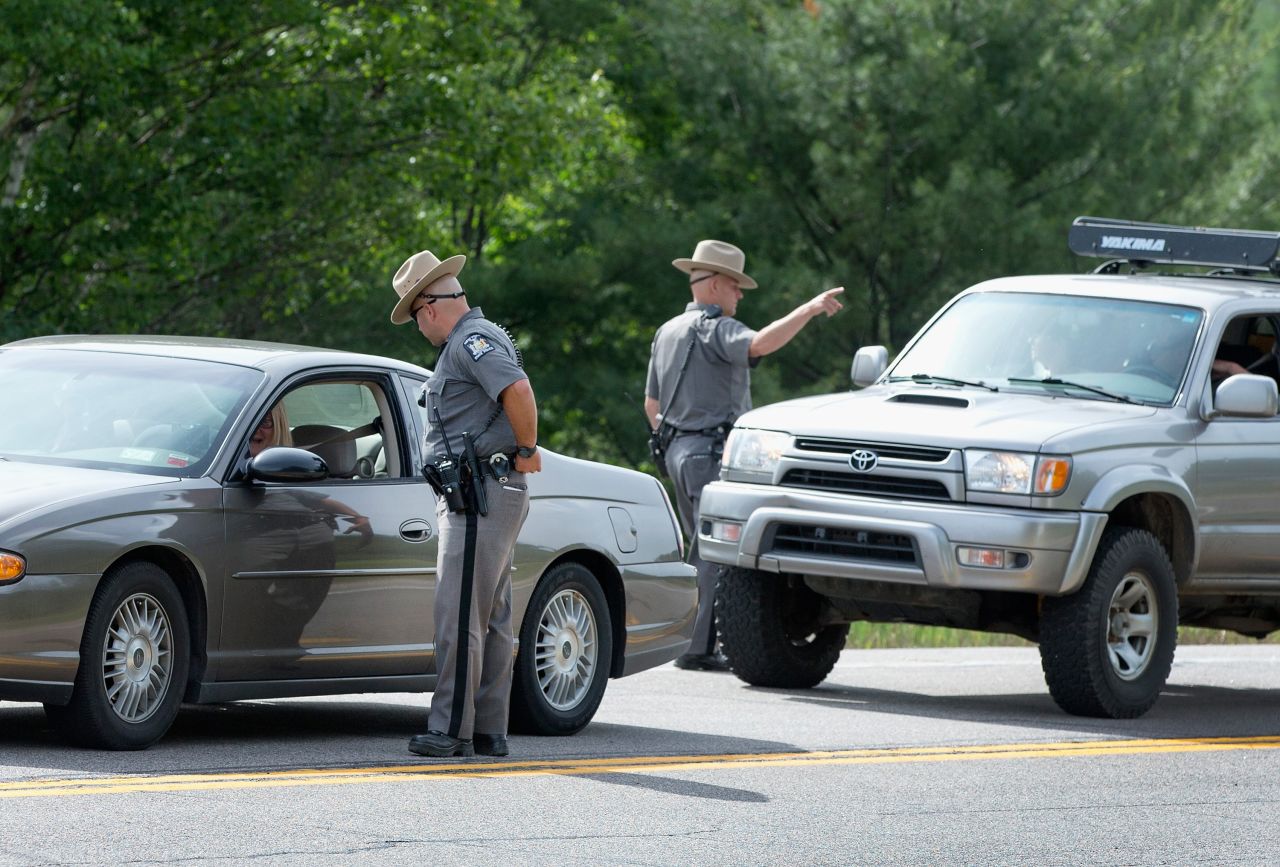 New York State Police officers talk to motorists at a roadblock near Malone on June 27.