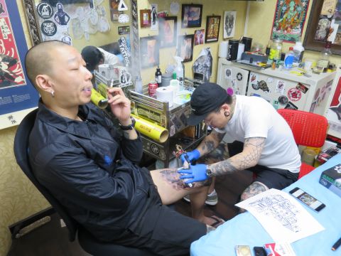 He Wei, a 37 year old freelance designer from Beijing getting inked up at Creation Tattoo. He says that without tattoos his body would feel so empty. 