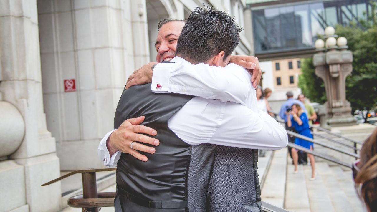 Carlos Santos-Herrera and David Herrera-Santos embrace on the courthouse steps. 