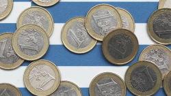 Euro coins over Greek flag