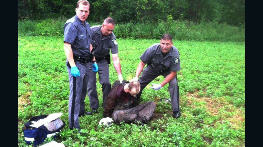 Police stand over David Sweat after he was shot and captured near the Canadian border Sunday, June 28, 2015, in Constable, N.Y. Sweat is the second of two convicted murderers who staged a brazen escape three weeks ago from a maximum-security prison in northern New York. His capture came two days after his escape partner, Richard Matt, was shot and killed by authorities. (AP Photo)