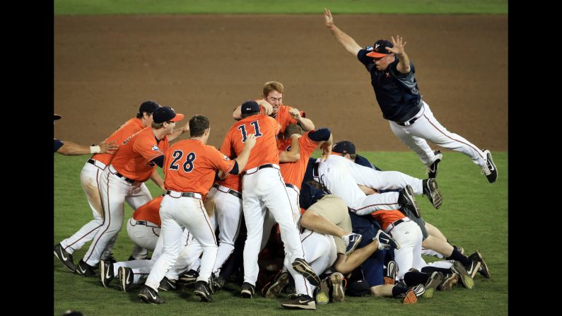 Assistant coach Matt Kirby jumps onto a pile of players after Virginia defeated Vanderbilt to win the College World Series on Wednesday, June 24. It was the first national title for Virginia, which lost to Vanderbilt last year in the championship series.