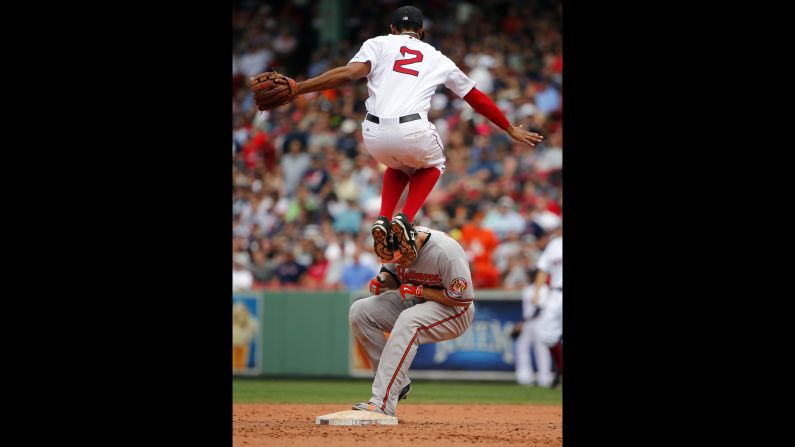 Boston's Xander Bogaerts leaps over second base to avoid Baltimore's Chris Davis, who had just hit a double on Thursday, June 25.