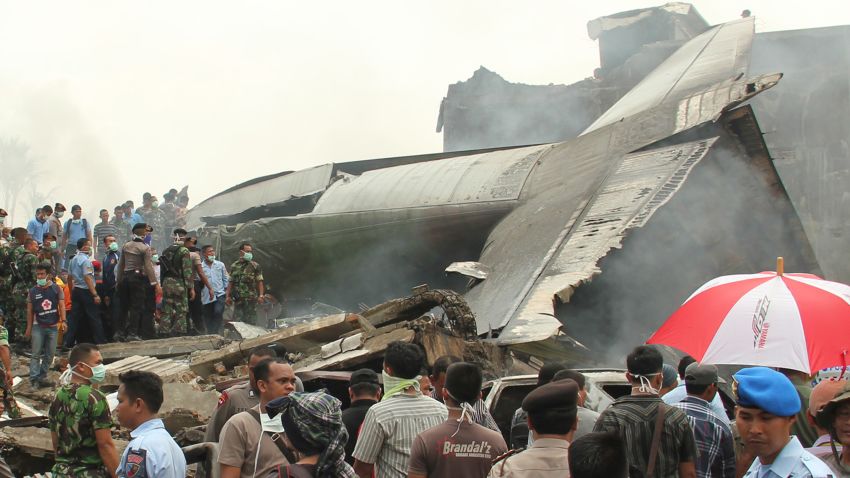 Military personnel inspect the wreckage of an Indoensian Air Force cargo plane that crashed in Medan, Indonesia, on Tuesday, June 30.