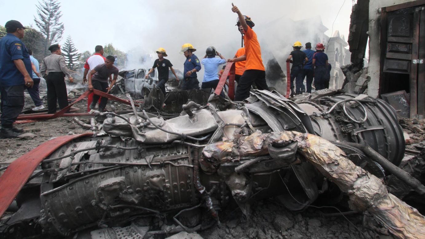 Firefighters work at the crash site in Medan.