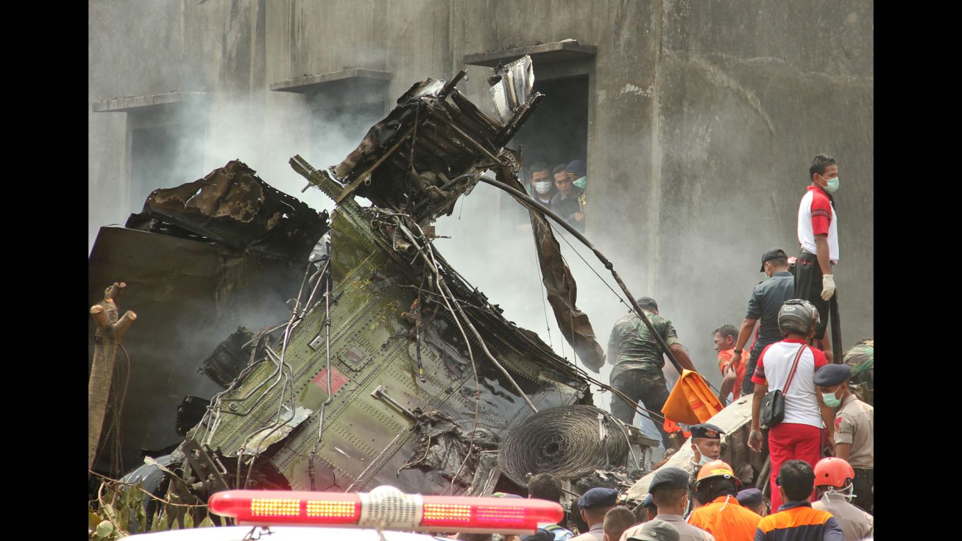 People search for victims around the wreckage.