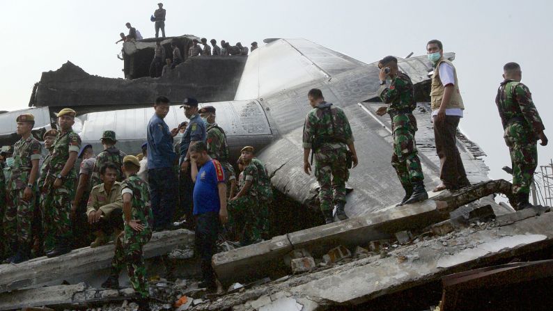 Search and rescue personnel comb through the wreckage of the plane.