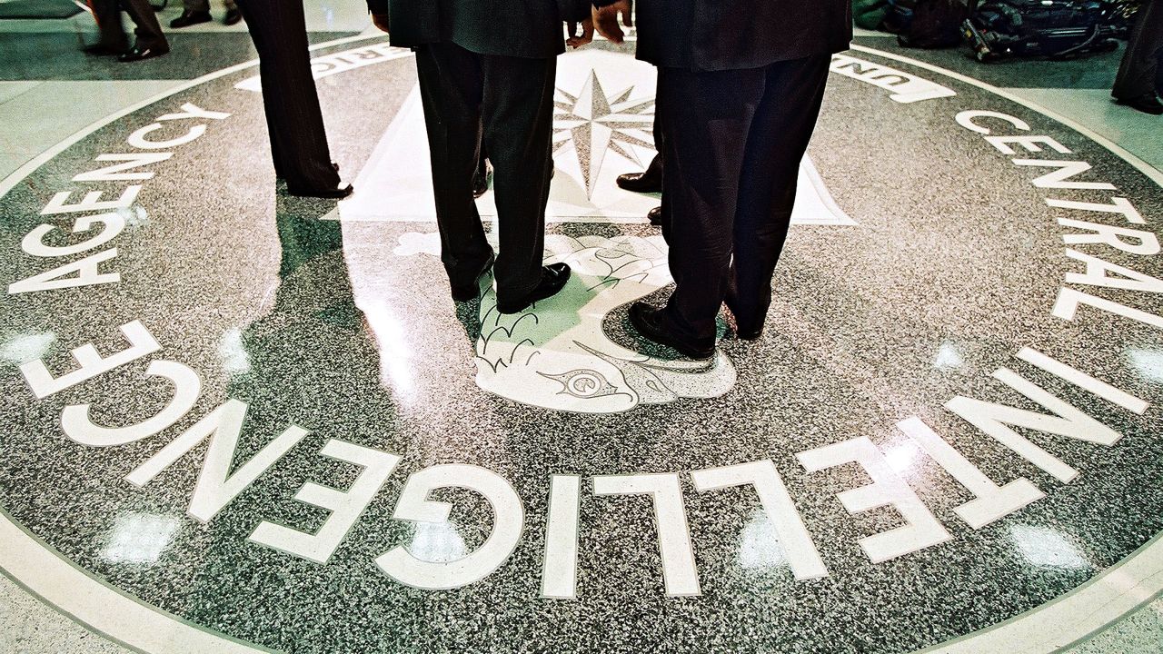 President George W. Bush, Central Intelligence Agency Director George Tenet and others stand on the seal of the Agency March 20, 2001 at the CIA Headquarters in Langley, Virginia. Bush toured the facility and met some of the Agency''s employees.