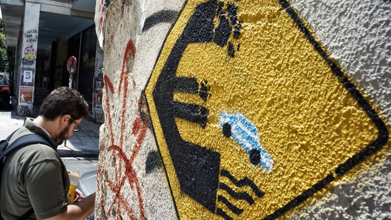 Caption:ATHENS, GREECE - JUNE 30: A man walks past anti-EU graffiti on June 30, 2015 in Athens, Greece. Greek voters will decide in a referendum next Sunday on whether their government should accept an economic reform package put forth by Greece's creditors. Greece has imposed capital controls with the banks being closed until the referendum and a daily limit of 60 euros has been placed on cash withdrawals from ATMs. (Photo by Milos Bicanski/Getty Images)