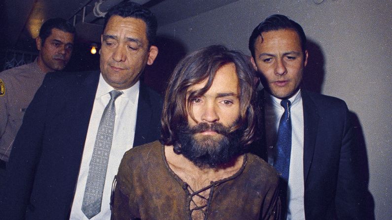<a href="index.php?page=&url=https%3A%2F%2Fwww.cnn.com%2F2013%2F09%2F30%2Fus%2Fmanson-family-murders-fast-facts%2Findex.html" target="_blank">The Manson Family murders</a> of Sharon Tate, the pregnant wife of filmmaker Roman Polanski, and others in the summer of 1969 shocked and captivated America, setting the tone for one of the most violent decades in the country's history as covered in the "Crimes and Cults" episode of CNN's "<a href="index.php?page=&url=https%3A%2F%2Fwww.cnn.com%2Fshows%2Fthe-seventies" target="_blank">The Seventies</a>." Here, Charles Manson is escorted to his arraignment on conspiracy-murder charges in connection with the case.