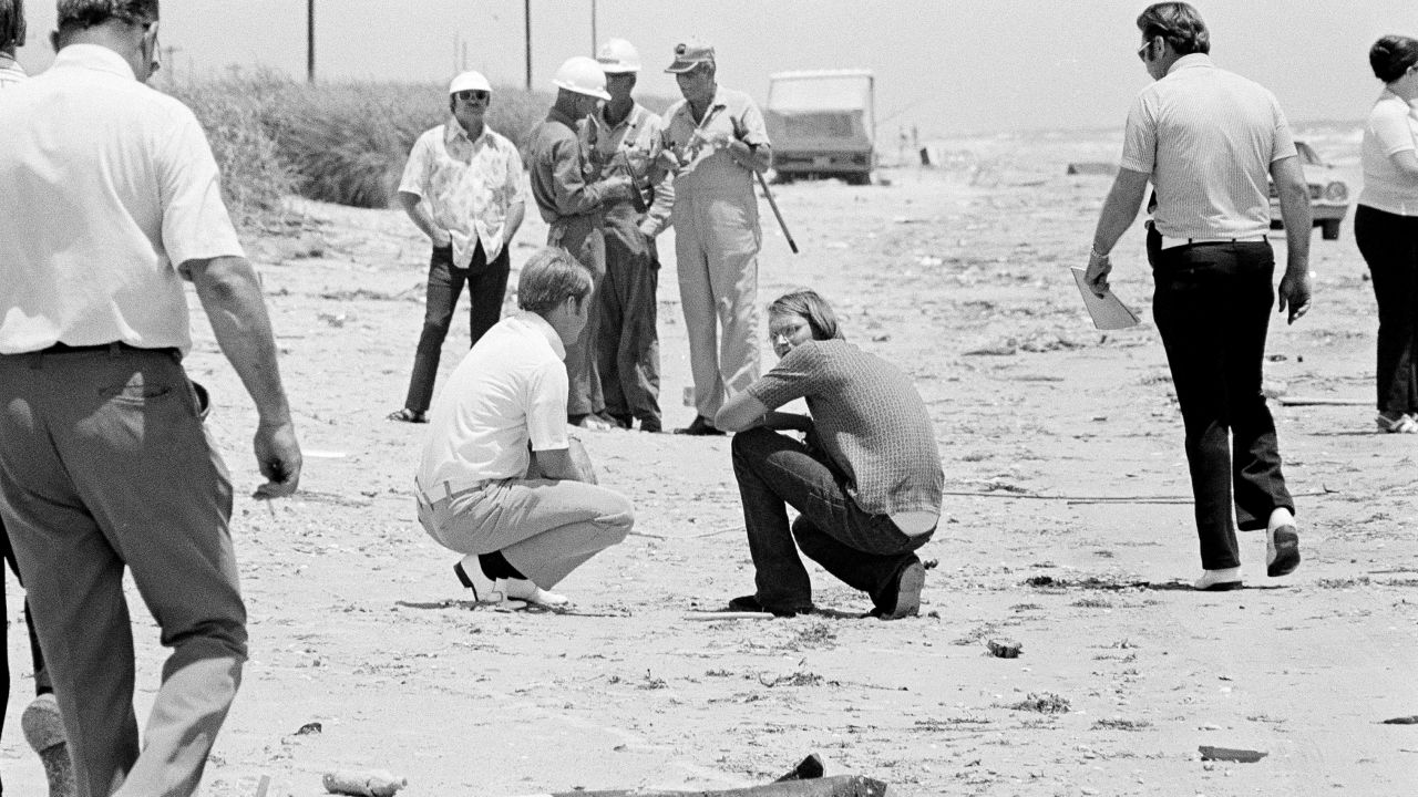 David Brooks, 18, right, squats on the beach with a law enforcement official as police search for bodies in High Island, Texas, in 1973. Brooks was implicated with Elmer Wayne Henley and Dean Corll, in the murders of at least 24 young men in a mass slaying case. "Dean Corill would pick up kids, and once he had them in his house, he would incapacitate them and put them on what he called his "death board" and rape and kill them," according to Stephen G. Michaud, author of "The Only Living Witness." Corll died in 1973.