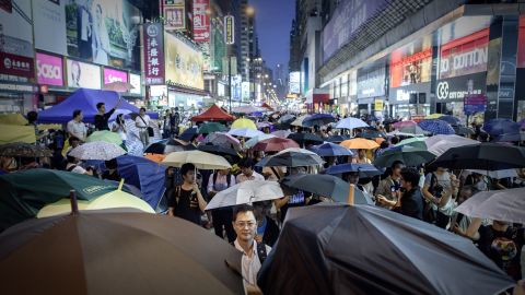 Pro-democracy protesters open their umbrellas to mark one month since they took to the streets, in the Mongkok district of Hong Kong on October 28, 2014. Hong Kong democracy activists on October 28 marked one month of mass protests, calling on supporters to gather for an evening rally wearing the masks they have used to ward off police tear gas and pepper spray. AFP PHOTO / Philippe Lopez        (Photo credit should read PHILIPPE LOPEZ/AFP/Getty Images)