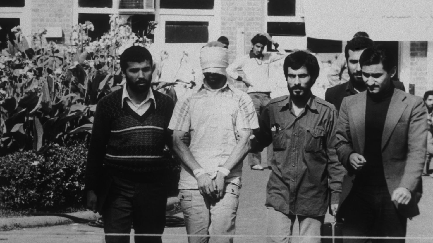 An American hostage being paraded before the cameras by his Iranian captors. Following the Iranian revolution over fifty American hostages were taken and only released after four hundred and forty-four days.