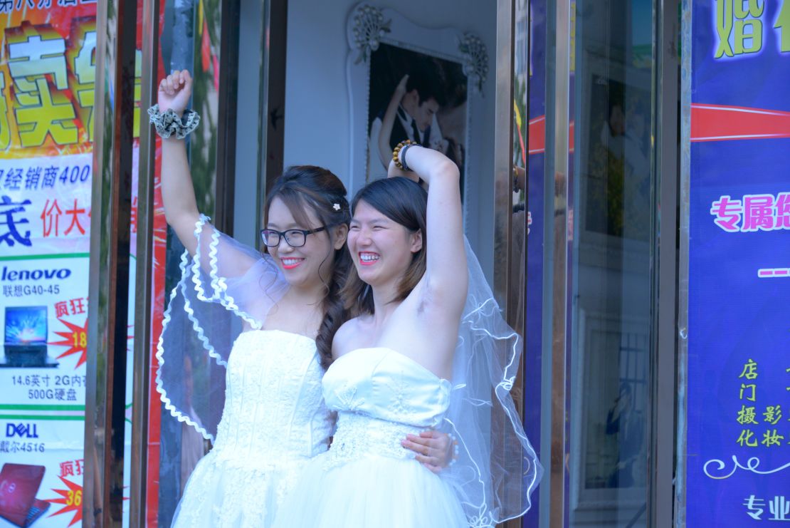 Teresa Xu, left, and Li Tingting, right, share a moment outside a beauty salon, where the two were preparing for their wedding.