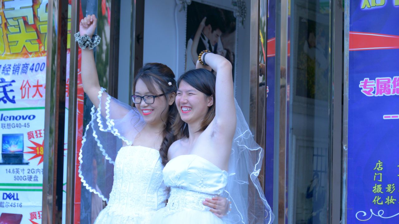 Teresa Xu, left, and Li Tingting, right, share a moment outside a beauty salon, where the two were preparing for their wedding.
