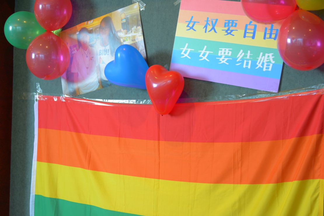 A rainbow flag hangs on the wall at the wedding. On top of it, the slogan reads: "Feminists longs for freedom. Lesbians want to get married."