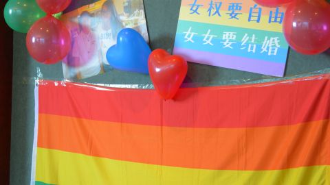 A rainbow flag hangs on the wall at the wedding. On top of it, the slogan reads: "Feminists longs for freedom. Lesbians want to get married."