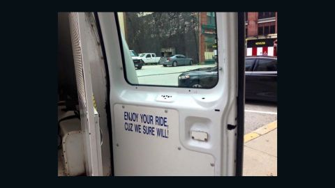 A sign inside the back door of a Baltimore police detainee transport vehicle warns about the ride