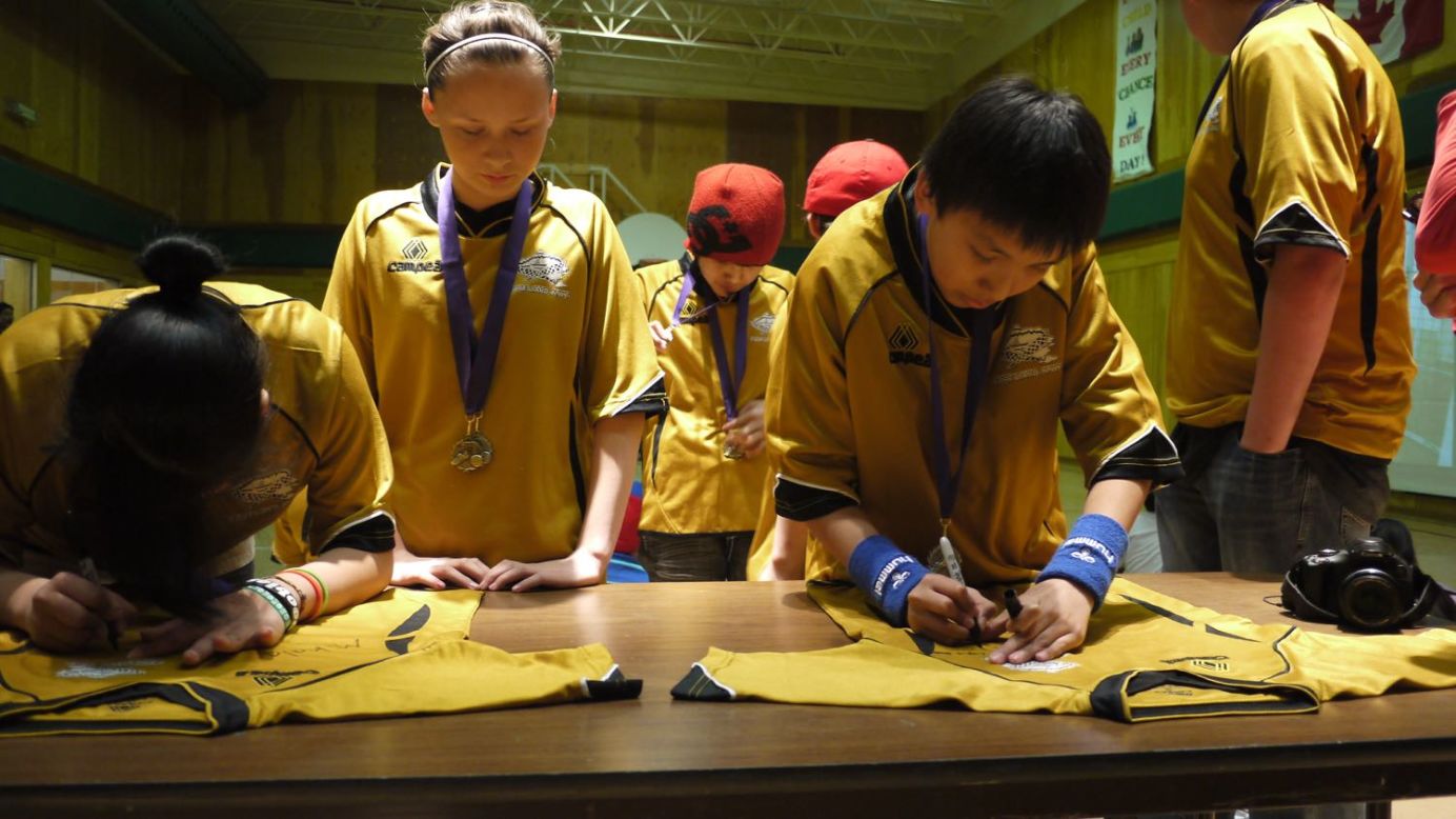 Fort Liard players sign commemorative jerseys, to be mounted on the walls of their school, following victory at a tournament in the neighboring town of Fort Simpson, almost 200 miles north.
