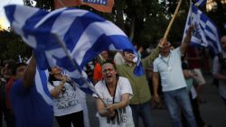 A supporter of the No vote waves a Greek flag after the referendum's exit polls at Syntagma square in Athens, Sunday, July 5.