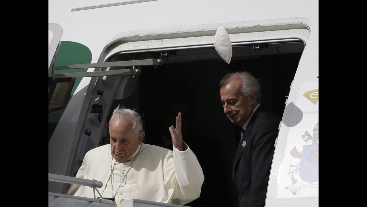 A gust of wind blows Pope Francis' skull cap upon his arrival at Quito Airport, Ecuador, Sunday.