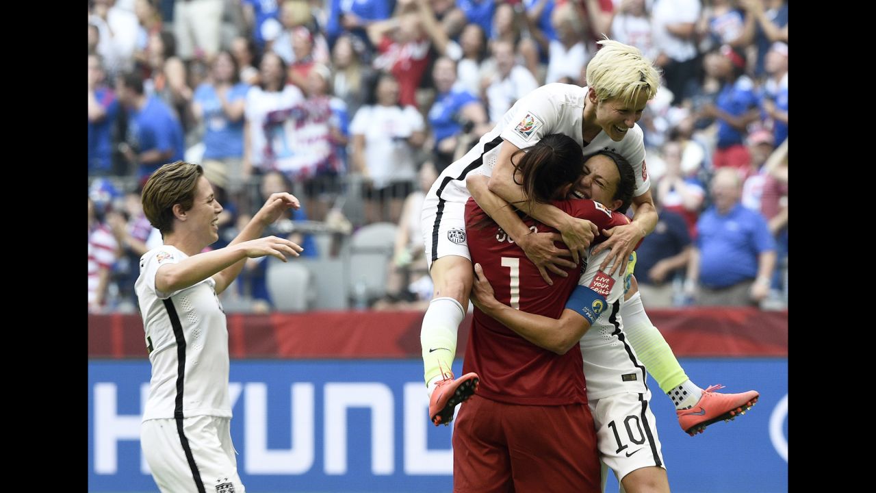 Lloyd is congratulated by teammates Hope Solo and Megan Rapinoe after scoring a goal.