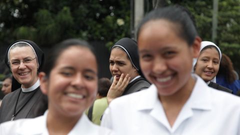 Nuns and faithful wait for Pope Francis to pass by after his arrival in Quito on July 5.