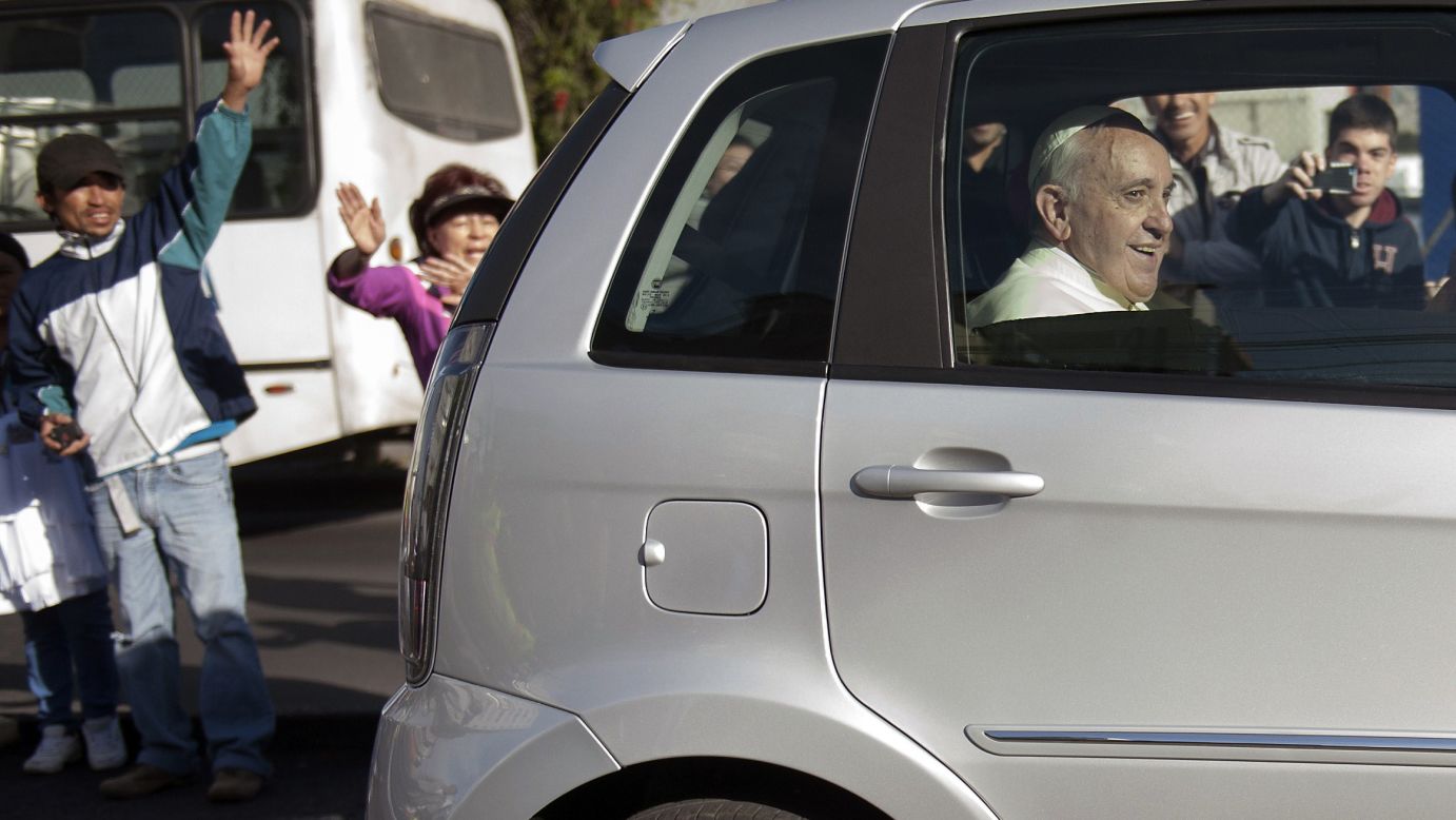 People wave as Pope Francis leaves the Apostolic Nunciature in Quito on July 6.