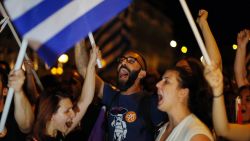 Supporters of the No vote react after the results of the referendum at Syntagma square in Athens, Sunday, July 5, 2015. Greece faced an uncharted future as its interior ministry predicted Sunday that more than 60 percent of voters in a hastily called referendum had rejected creditors' demands for more austerity in exchange for rescue loans.